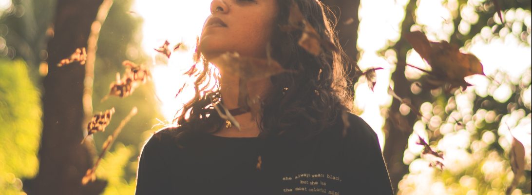 girl in woods falling leaves