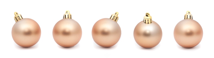 Line of five Gold Christmas balls on a white background with copyspace