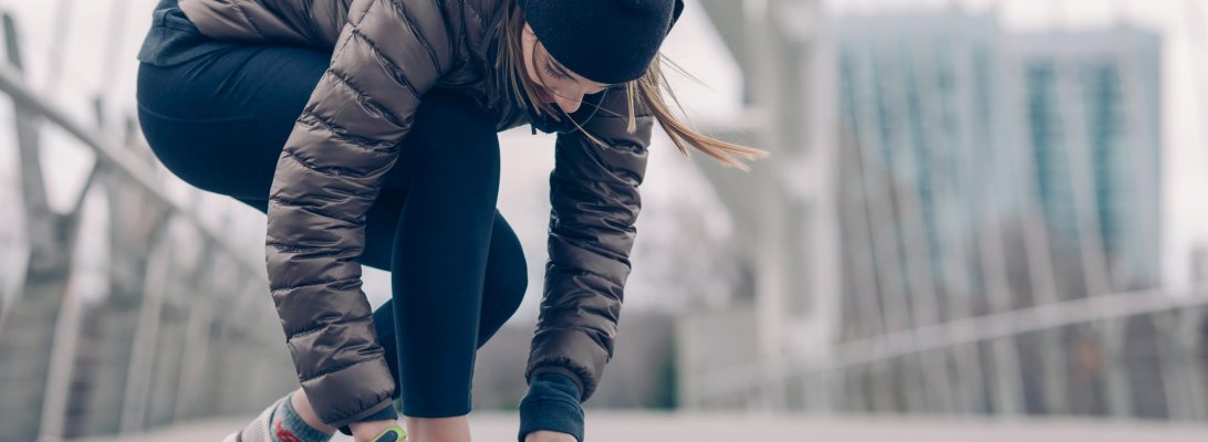 woman tying shoes in the city